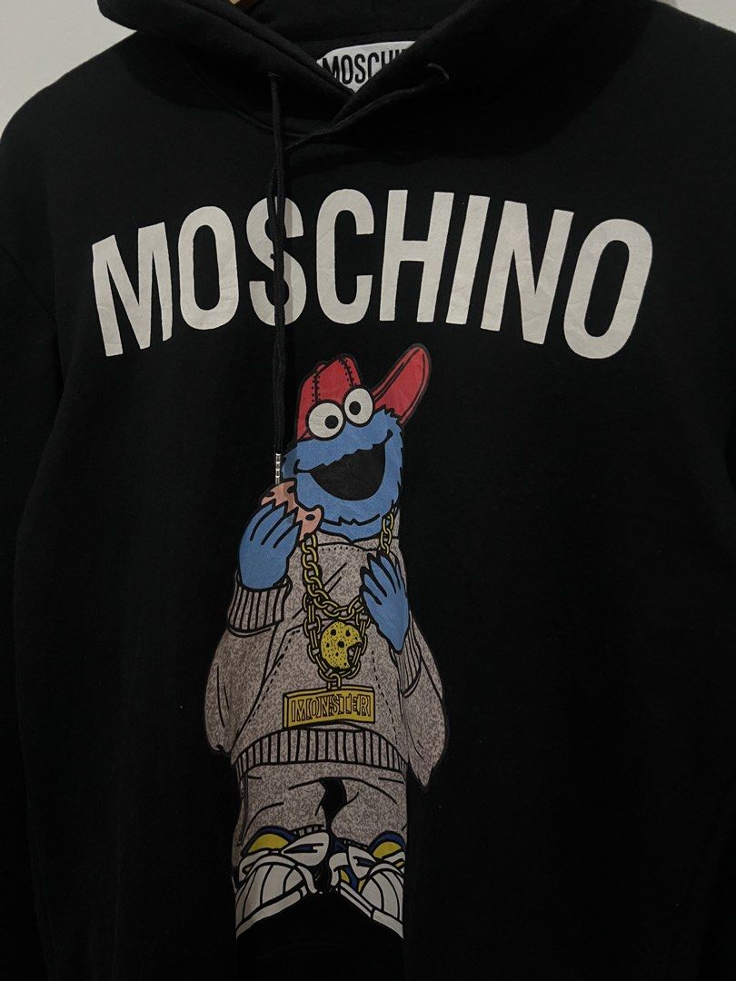Moschino Cookie Monster Hoodie (Category: Coats, Jackets and Outerwear) located in Manila. Submitted by dynoace (Listing ID 1433990706, Image 2). Description: - Moschino Cookie Monster Hoodie - Size: Medium - Made in Portugal - Material: 100% Cotton - Features: Drawstring, Hood, Moschino logo on chest.