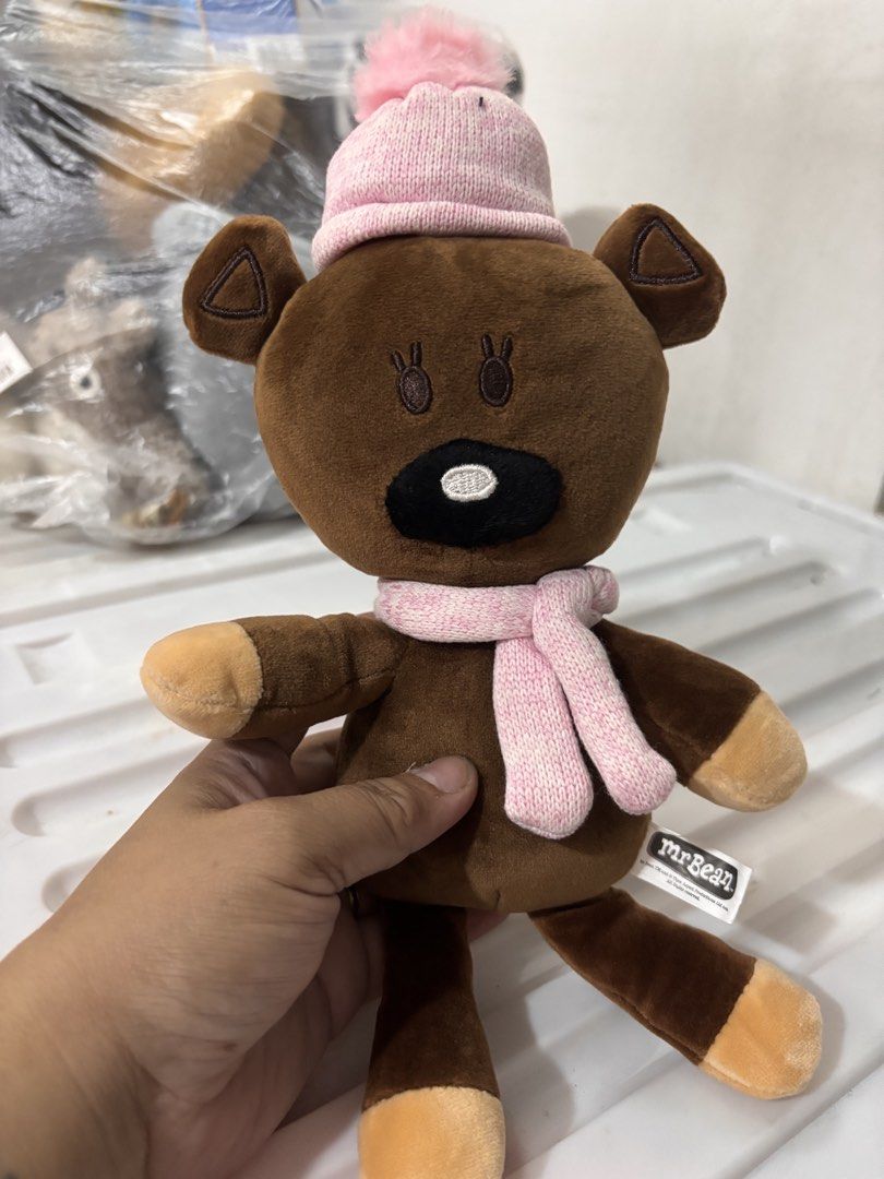 Mr. Bean Bear Plush Toy (Category: Toys & Games) located in Manila. Submitted by kathylandia (Listing ID 1433976852, Image 1). Description: - Adorable Mr. Bean bear plush toy - Features a pink hat and scarf - Soft brown fur with tan paw and foot accents - Detailed with embroidered eyes and a black nose - Perfect for Mr. Bean fans and plush toy collectors - Cute and cuddly design.