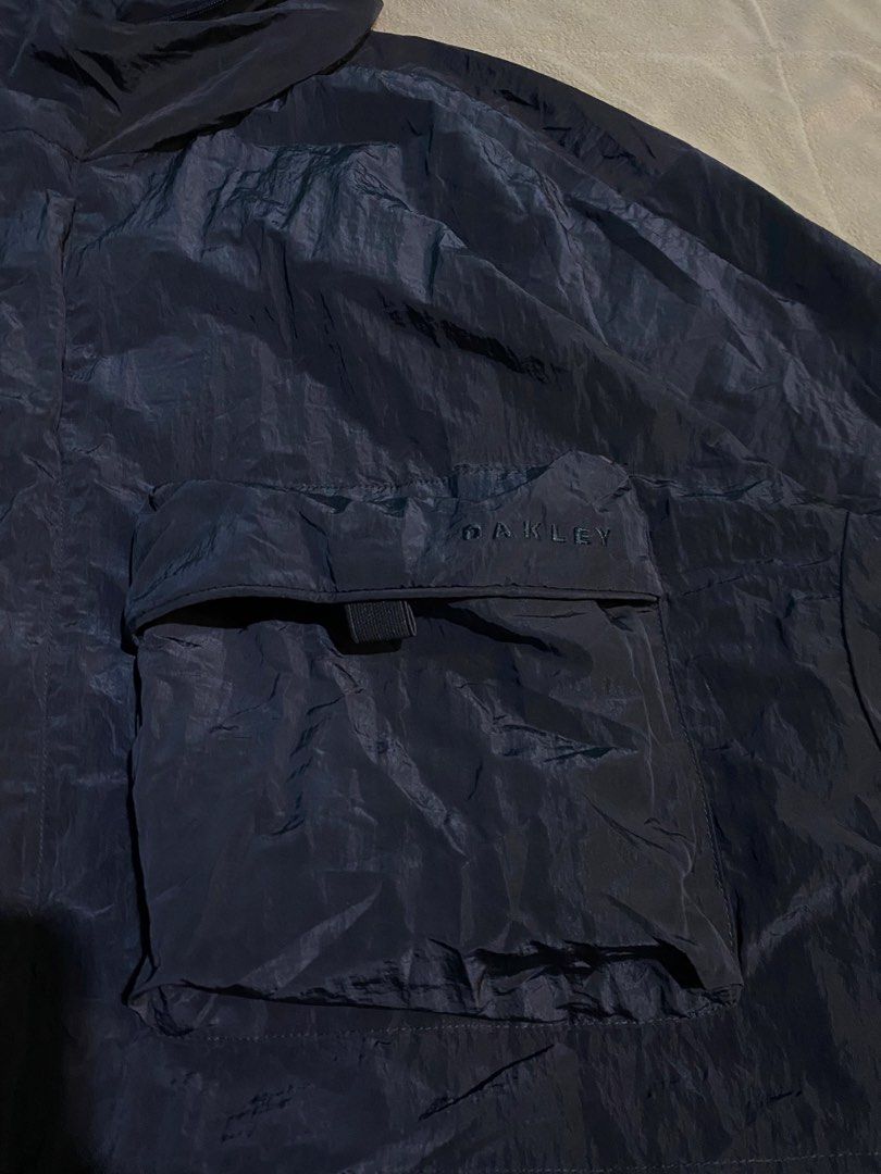 Oakley Regular Fit Jacket (Category: Coats, Jackets and Outerwear) located in Cebu City. Submitted by nardcen (Listing ID 1434126128, Image 2). Description: - Oakley navy blue jacket - Size: XL - Color: Navy Blue - Features a hood - Multiple pockets with zipper and velcro closures - Regular fit - Oakley logo on chest pocket - Made in China.