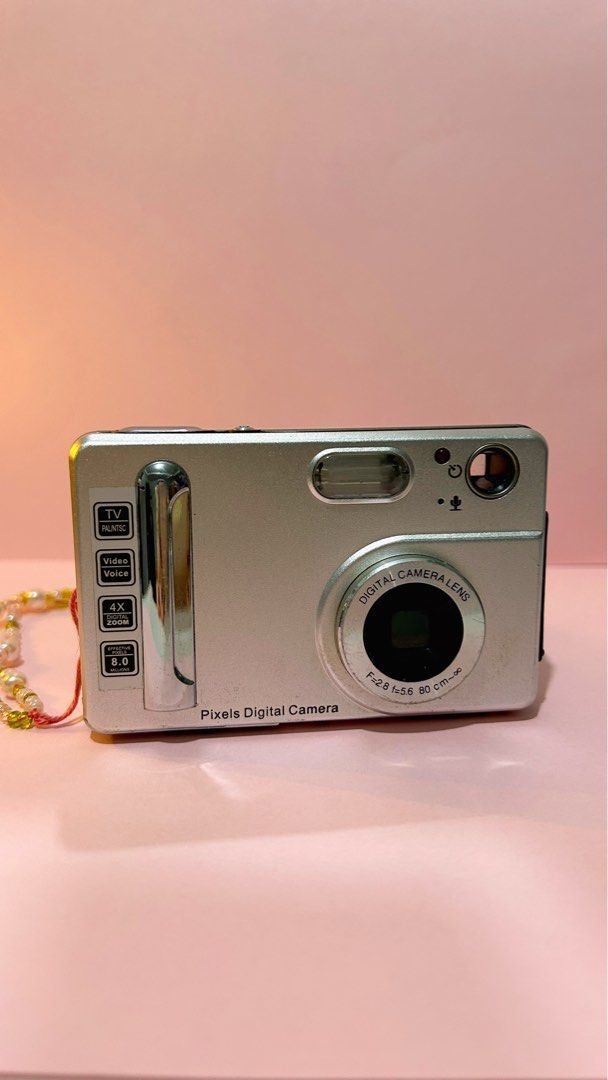 Pixels Digital Camera (Category: Cameras) located in Makati City. Submitted by belle.depop (Listing ID 1434015937, Image 1). Description: - Silver Pixels digital camera - 1.5" LTPS LCD screen - Features: TV, video, voice recording - 4x zoom - 8.0 MP - Includes decorative beaded strap - Lens: Digital Camera Lens f=2.8 f=5.6 80 cm-∞ 🍒 Issues: none. Scratches due to age/usage 🧳 Sample photos posted 🖼️ 🔋Powered by triple A batteries ✨Please manag