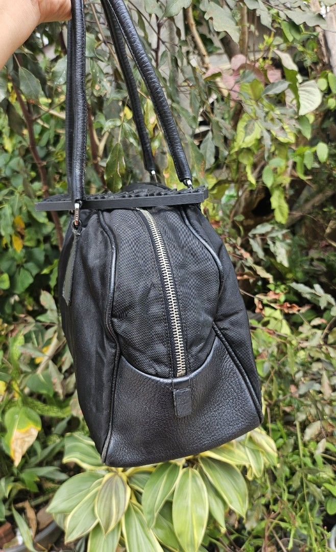 Prada Black Nylon Handbag (Category: Luxury Bags & Wallets) located in Pamplona. Submitted by luxuryitems_ph (Listing ID 1434124088, Image 3). Description: - Authentic Prada handbag - Black with leather accents - Zip closure - Double handles - Silver-tone hardware - Includes padlock (no key) - Prada logo on front - Interior Prada label - Minor wear on corners.