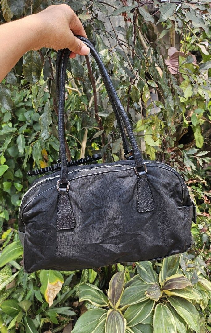 Prada Black Nylon Handbag (Category: Luxury Bags & Wallets) located in Pamplona. Submitted by luxuryitems_ph (Listing ID 1434124088, Image 2). Description: - Authentic Prada handbag - Black with leather accents - Zip closure - Double handles - Silver-tone hardware - Includes padlock (no key) - Prada logo on front - Interior Prada label - Minor wear on corners.