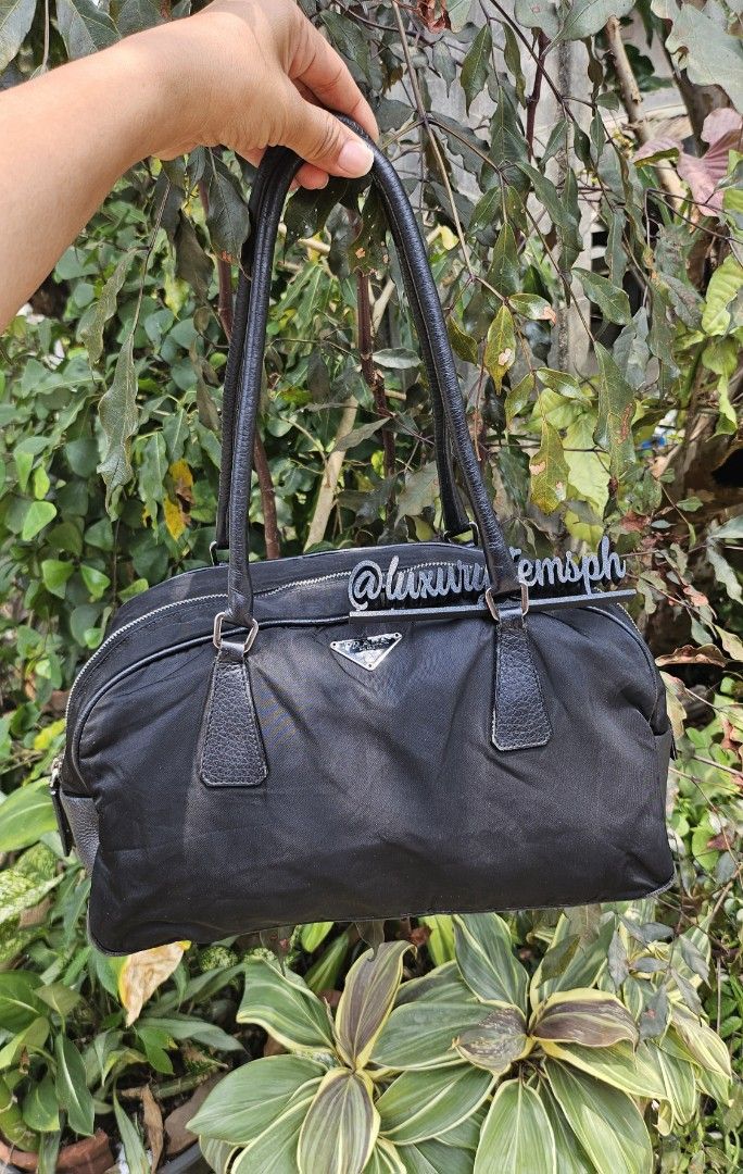 Prada Black Nylon Handbag (Category: Luxury Bags & Wallets) located in Pamplona. Submitted by luxuryitems_ph (Listing ID 1434124088, Image 1). Description: - Authentic Prada handbag - Black with leather accents - Zip closure - Double handles - Silver-tone hardware - Includes padlock (no key) - Prada logo on front - Interior Prada label - Minor wear on corners.