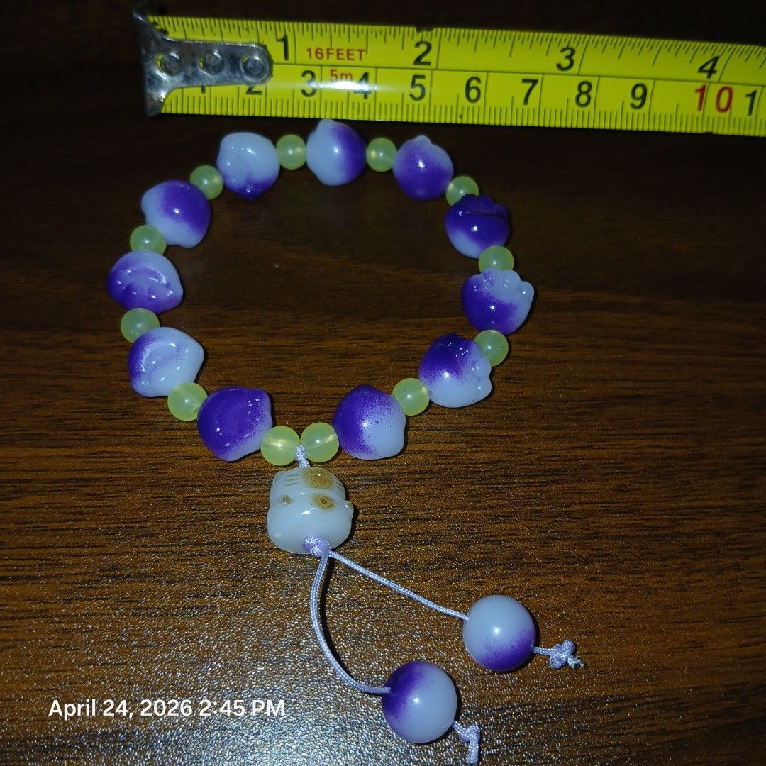 Purple and Green Beaded Bracelet (Category: Bracelets) located in Pasig City. Submitted by joe.pasig (Listing ID 1434039052, Image 1). Description: - Features a mix of purple and green beads - Purple beads have a unique shape - Green beads are round - Includes a white bead with a design - Finished with purple and white end beads - Strung on a durable white cord.