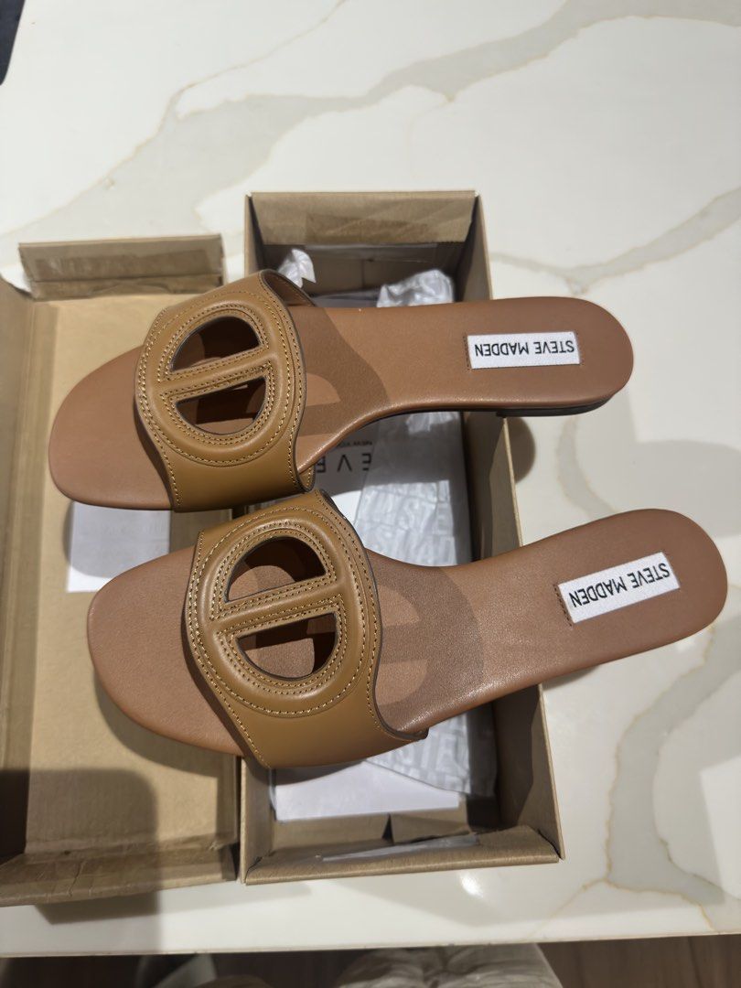 Steve Madden Kylah Tan Leather Sandals (Category: Flats & Sandals) located in San Fernando. Submitted by little_mavzzz (Listing ID 1434086430, Image 2). Description: Genuine Steve Madden Kylah sandals in tan leather. Features a stylish design with a distinctive 'O' detail on the straps. The sandals come with their original box. Size 8. Perfect for everyday wear or a casual outing. Comfortable and fashionable..