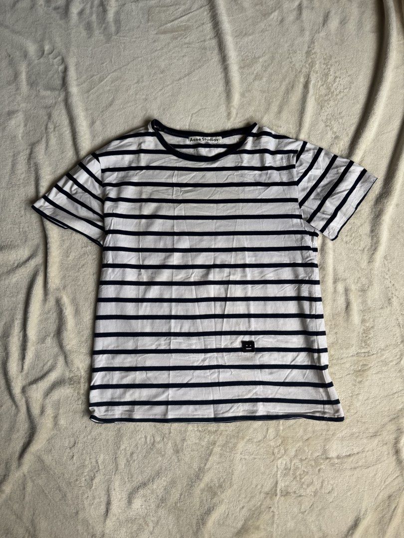 Acne Studios Striped T-shirt (Category: Tshirts & Polo Shirts ) located in Manila. Submitted by ffranzledesma (Listing ID 1434271818, Image 1). Description: - Acne Studios striped t-shirt - Color: White and navy blue - Features a classic crew neck - Short sleeves - Acne Studios logo detail on neckline - Small logo patch on front - Horizontal stripes throughout Description: size M Dimes: L - 26 in W - 20 in MOP: Gcash or Maya MOD: Lalamove or J&T.