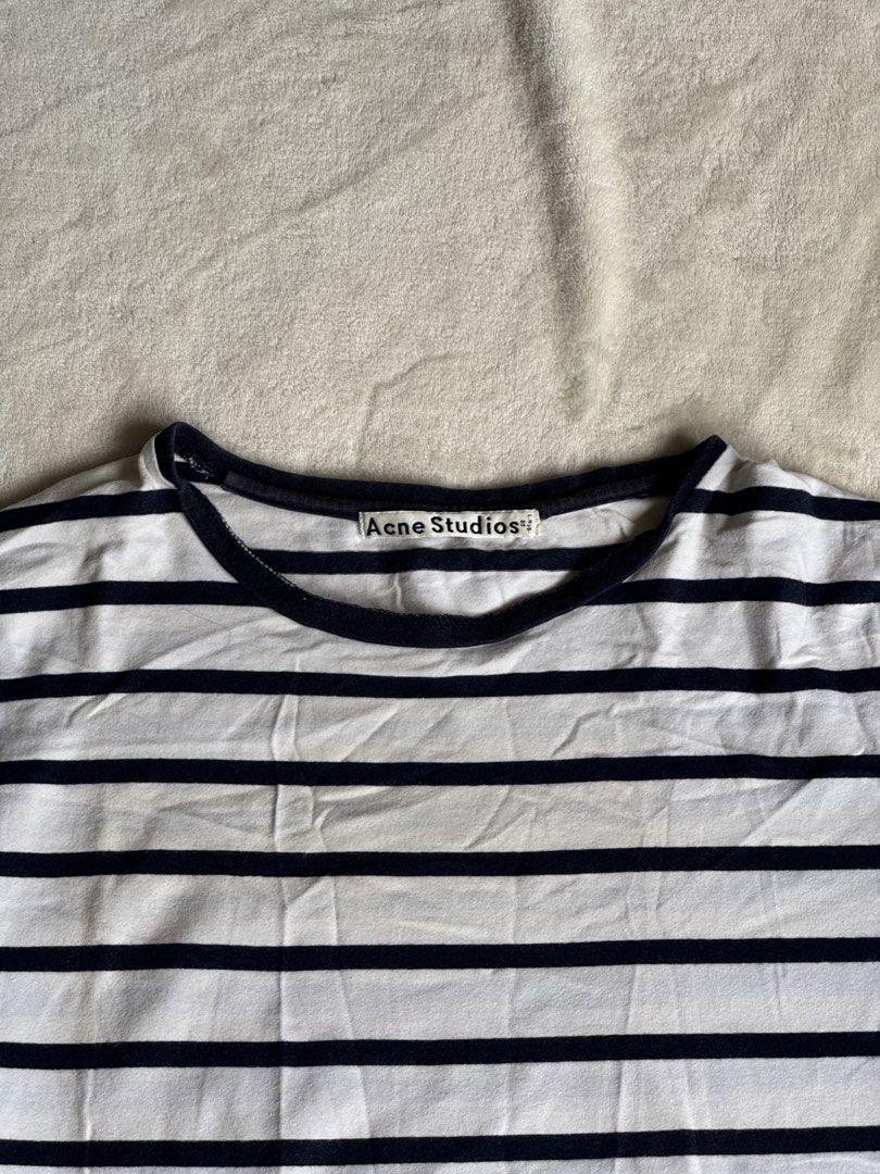 Acne Studios Striped T-shirt (Category: Tshirts & Polo Shirts ) located in Manila. Submitted by ffranzledesma (Listing ID 1434271818, Image 2). Description: - Acne Studios striped t-shirt - Color: White and navy blue - Features a classic crew neck - Short sleeves - Acne Studios logo detail on neckline - Small logo patch on front - Horizontal stripes throughout Description: size M Dimes: L - 26 in W - 20 in MOP: Gcash or Maya MOD: Lalamove or J&T.