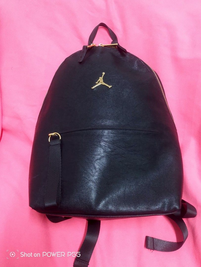 Air Jordan Black Backpack (Category: Backpacks) located in Binan City. Submitted by stuffshop29 (Listing ID 1434236275, Image 3). Description: - Black Air Jordan backpack - Gold Jumpman logo and gold zippers with "JORDAN" engraving - Adjustable straps - Small front pocket - Red striped interior lining with "AIR JORDAN" logo - Leather-like material - Size: S.