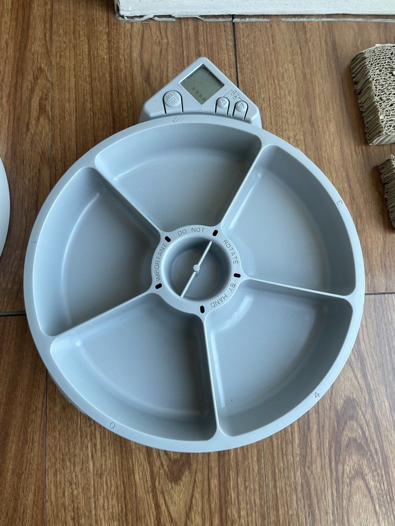 Cat Mate Automatic Dry/Wet Food Feeder (Category: Homes & Other Pet Accessories) located in Pasig City. Submitted by jakejake.150be9 (Listing ID 1434271142, Image 2). Description: - Cat Mate automatic pet feeder. - Rotating tray with 5 compartments for portion control. - Can be used for wet food - Includes ice packs to keep food fresh. - Digital display and timer function. - Requires 3x AA batteries (not included). - Color: White and gray..