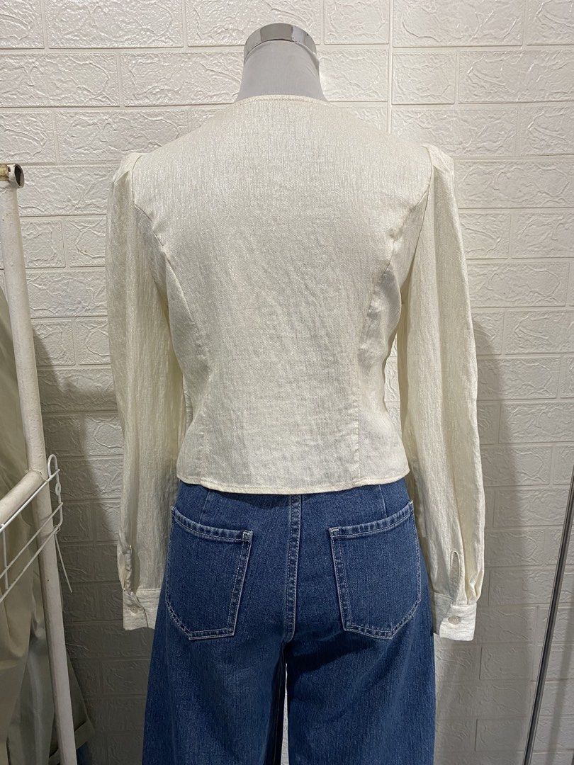 Cream-colored Long Sleeve Office Blouse (Category: Blouses) located in Manila. Submitted by anneeem (Listing ID 1433272660, Image 3). Description: - Elegant cream blouse - Long sleeves - V-neckline - Button-down front - Ruched detail - Unique cut - Puff sleeves - Sophisticated style.
