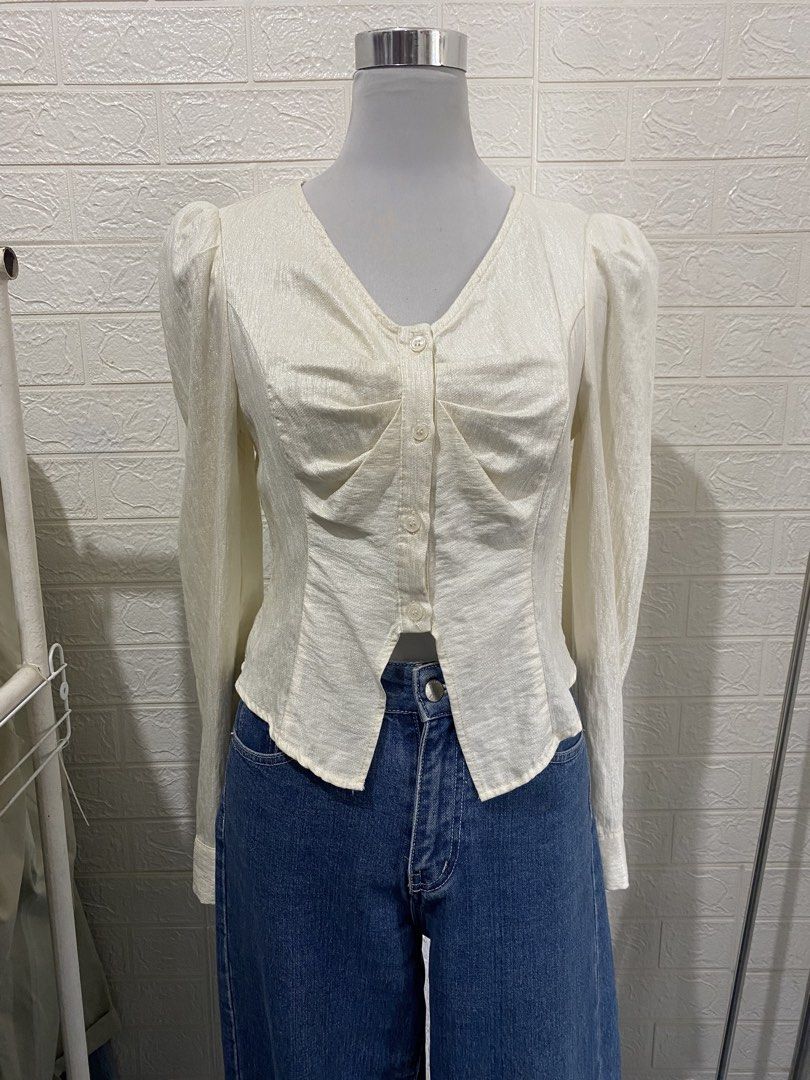 Cream-colored Long Sleeve Office Blouse (Category: Blouses) located in Manila. Submitted by anneeem (Listing ID 1433272660, Image 1). Description: - Elegant cream blouse - Long sleeves - V-neckline - Button-down front - Ruched detail - Unique cut - Puff sleeves - Sophisticated style.