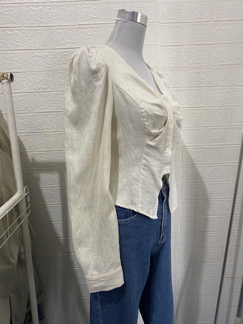 Cream-colored Long Sleeve Office Blouse (Category: Blouses) located in Manila. Submitted by anneeem (Listing ID 1433272660, Image 2). Description: - Elegant cream blouse - Long sleeves - V-neckline - Button-down front - Ruched detail - Unique cut - Puff sleeves - Sophisticated style.