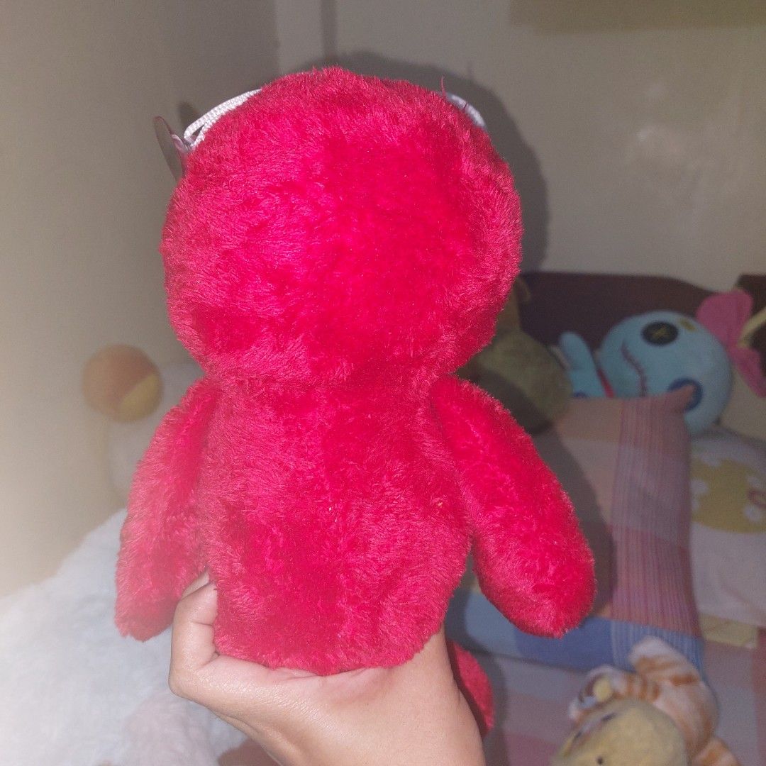 Elmo Kaws - no etiketa (Category: Plushies & Soft Toys) located in Mandaluyong City. Submitted by 13thsilverrabbit (Listing ID 1434188961, Image 3). Description: Unique red plush toy features distinctive white eyes with black "X" markings. It has a smiling black mouth and a small orange nose. The toy is soft and plush, with a distinctive shape..