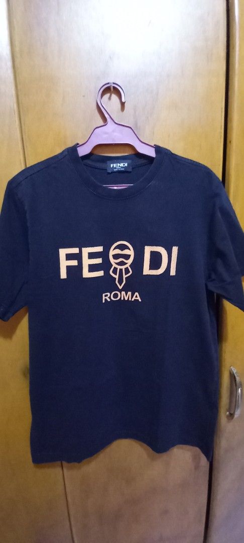 Fendi Roma Black T-shirt (Category: Shirts) located in Las Pinas. Submitted by mickey4224 (Listing ID 1434178993, Image 1). Description: - Fendi T-shirt - Black with gold "FENDI ROMA" logo - Material: 100% cotton - Measurements: Approximately 19" chest, 26" length - Includes care instructions -From balikbayan box slightly used sent by my family abroad in the US. -Crack print..