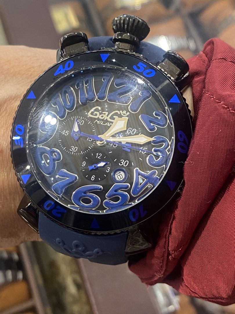 GaGa Milano Watch (Category: Luxury Watches) located in Manila. Submitted by roseluxuryitems (Listing ID 1434223407, Image 3). Description: - GaGa Milano watch with a unique design. - Black dial with large, blue numerals. - Blue rubber strap. - Black bezel with blue markings. - Multiple sub-dials and pushers. - Water-resistant to 100M. - Marked "GaGa Milano" and "100M WATER ITALY" on the back. - Made in Italy..