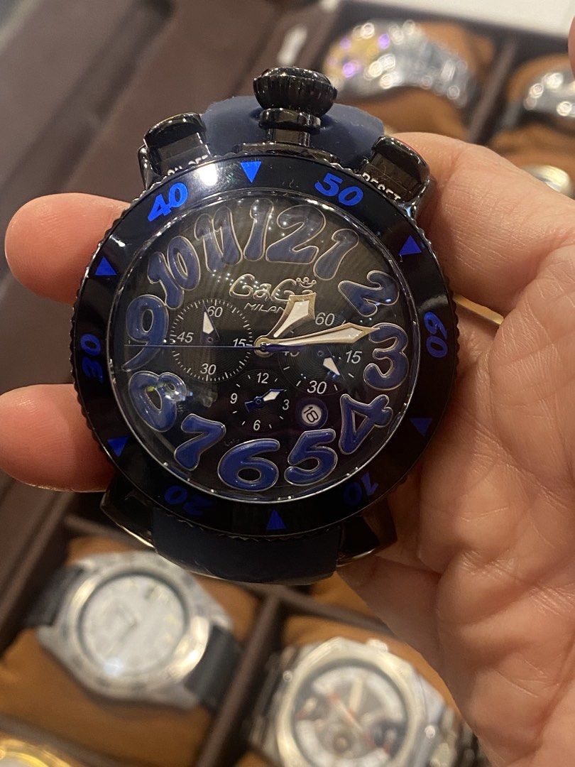 GaGa Milano Watch (Category: Luxury Watches) located in Manila. Submitted by roseluxuryitems (Listing ID 1434223407, Image 1). Description: - GaGa Milano watch with a unique design. - Black dial with large, blue numerals. - Blue rubber strap. - Black bezel with blue markings. - Multiple sub-dials and pushers. - Water-resistant to 100M. - Marked "GaGa Milano" and "100M WATER ITALY" on the back. - Made in Italy..