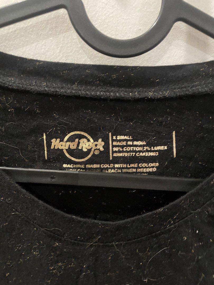 Hard Rock Cafe Dubai Ladies Tee XS (Category: Shirts) located in Shah Alam. Submitted by arliajuli54930 (Listing ID 1434279419, Image 2). Description: - Authentic Hard Rock Cafe Dubai Ladies Tee - Size: XS - Color: Black - Features a metallic gold logo - Material: 98% cotton, 2% lurex - Made in India - Original Price: AED 120.00 - Crew neck and short sleeves.