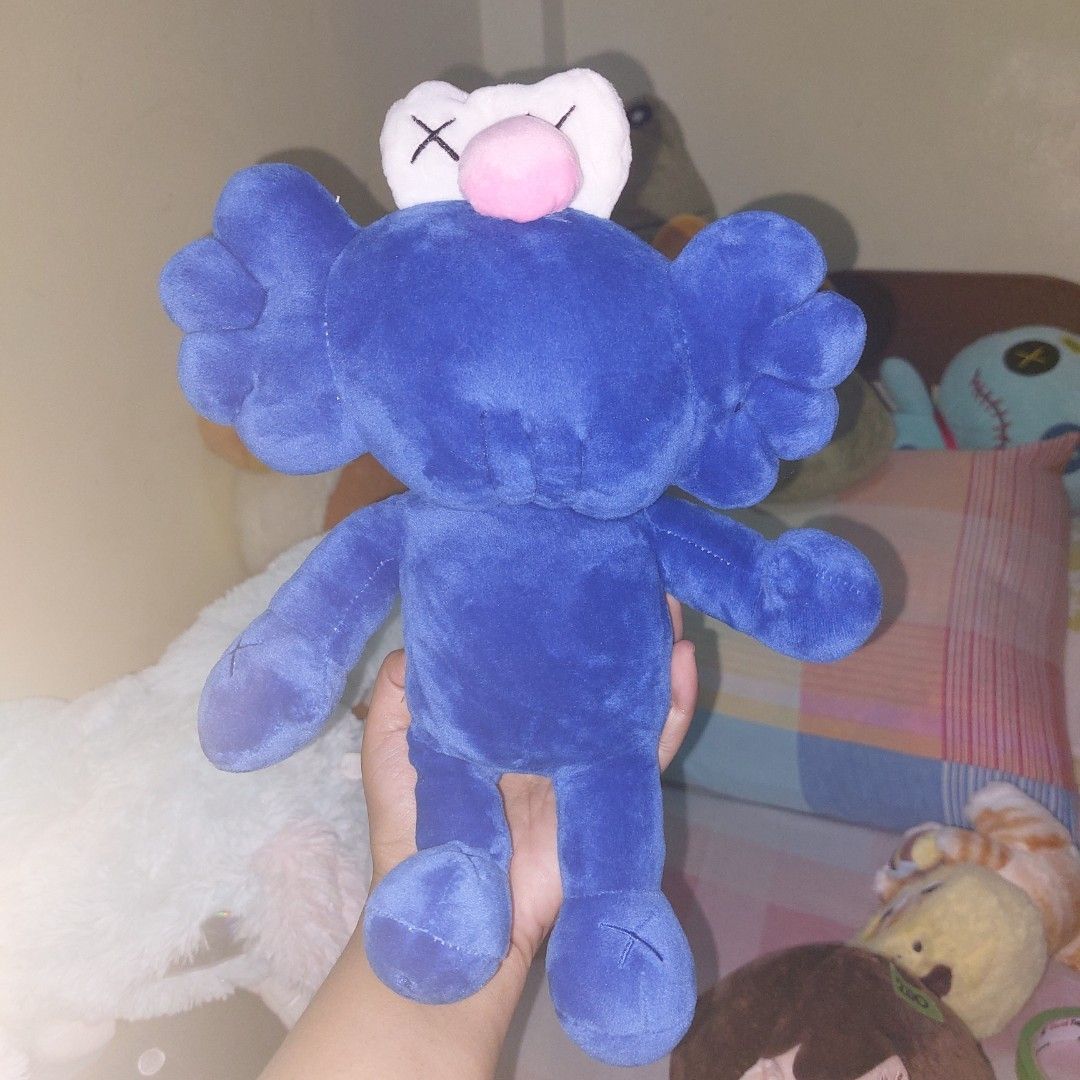 KAWS Plush Toys (Category: Plushies & Soft Toys) located in Mandaluyong City. Submitted by 13thsilverrabbit (Listing ID 1434189900, Image 3). Description: Collection of KAWS plush toys in various colors. Includes blue, black, white, gray, and brown figures. Also includes a red Elmo-like plush toy with X eyes. These plush toys are soft and cuddly, perfect for display or as a gift..