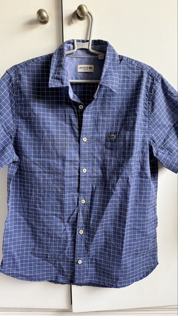 Lacoste Slim Fit Checkered Shirt (Category: Tshirts & Polo Shirts ) located in Valenzuela. Submitted by dees.corner (Listing ID 1434195521, Image 1). Description: -Lacoste Slim Fit short-sleeved shirt in blue checkered pattern. -Features a chest pocket with the Lacoste logo. -The shirt has a button-down closure and a classic collar. Size M, made in China. -The shirt has a buttoned cuff. -W16 L27.