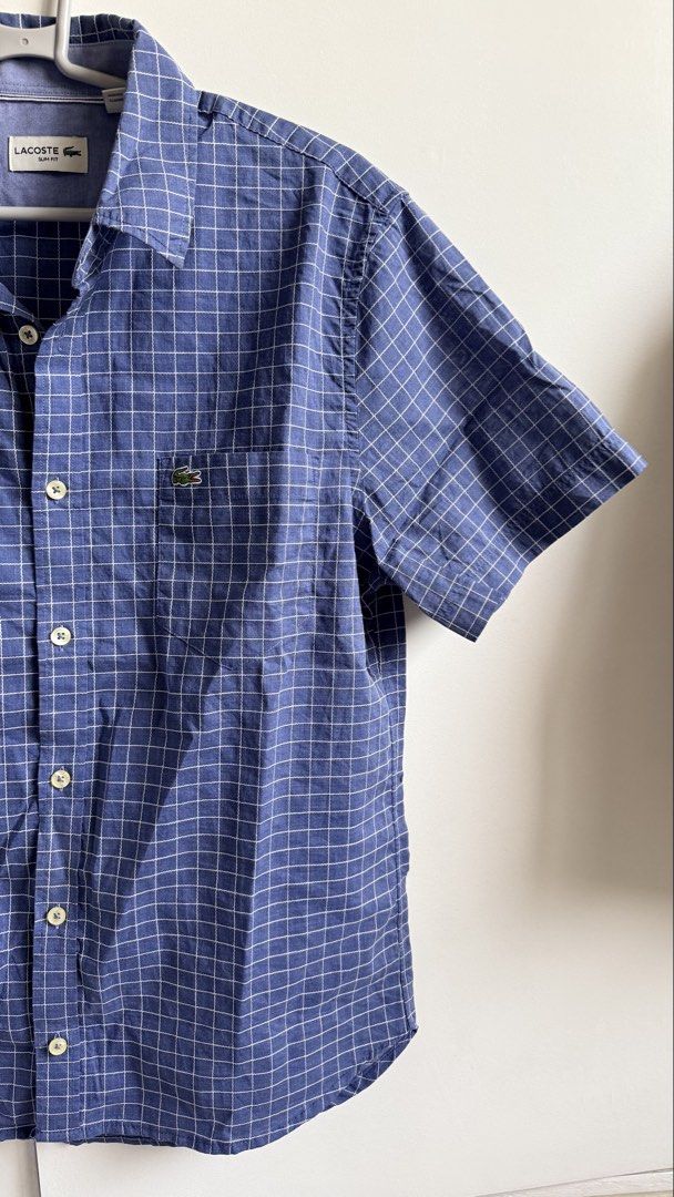 Lacoste Slim Fit Checkered Shirt (Category: Tshirts & Polo Shirts ) located in Valenzuela. Submitted by dees.corner (Listing ID 1434195521, Image 2). Description: -Lacoste Slim Fit short-sleeved shirt in blue checkered pattern. -Features a chest pocket with the Lacoste logo. -The shirt has a button-down closure and a classic collar. Size M, made in China. -The shirt has a buttoned cuff. -W16 L27.