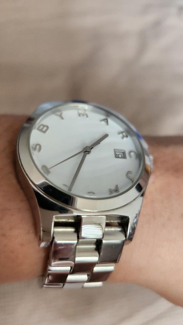 Marc Jacobs Silver Watch (Category: Luxury Watches) located in Cavite. Submitted by geturs (Listing ID 1434256172, Image 3). Description: - Marc Jacobs watch - Silver stainless steel band - White dial - Date display at 3 o'clock - Silver bezel with brand name - Clasp closure.