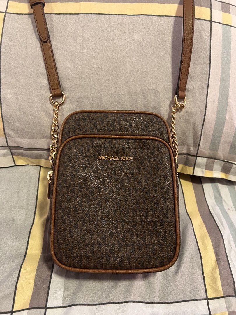Michael Kors Brown Crossbody Bag (Category: Cross-body Bags) located in Manila. Submitted by mrac10 (Listing ID 1434202450, Image 3). Description: - Michael Kors crossbody bag - Brown monogram pattern - Gold chain and adjustable brown strap - Zip closure - Interior pocket - Michael Kors branded lining - Gold zipper pull with Michael Kors logo - authentic Given as gift .