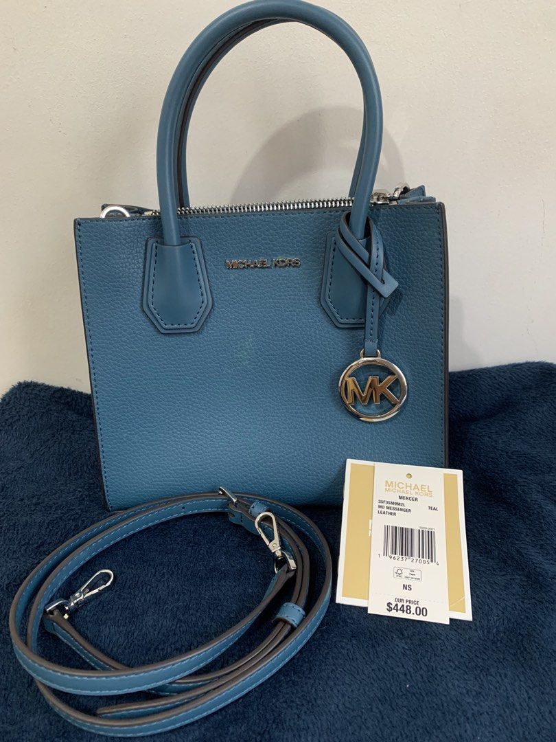 Michael Kors Mercer Small Top-Handle Bag (Category: Luxury Bags & Wallets) located in Paranaque City. Submitted by yammmyh (Listing ID 1434203080, Image 1). Description: - Michael Kors Mercer bag - Color: Blue - Hardware: Silver-tone - Features: Top handle, detachable shoulder strap - Closure: Zip - Interior: Zip pocket - Includes metal logo charm - Original price tag included ($448) - used only once.