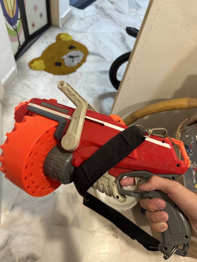 Nerf MEGA Centurion Blaster (Category: Action & Battle Toys) located in Kuala Lumpur. Submitted by zacchchan_166 (Listing ID 1434291939, Image 2). Description: - Nerf MEGA Centurion blaster - Bold red and orange color scheme - Features a large rotating drum - Includes a convenient shoulder strap - Gray handle - "MEGA" branding on the side - In good working condition.