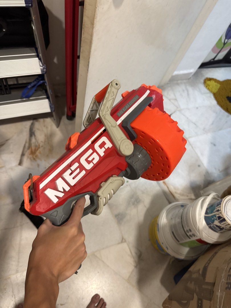 Nerf MEGA Centurion Blaster (Category: Action & Battle Toys) located in Kuala Lumpur. Submitted by zacchchan_166 (Listing ID 1434291939, Image 1). Description: - Nerf MEGA Centurion blaster - Bold red and orange color scheme - Features a large rotating drum - Includes a convenient shoulder strap - Gray handle - "MEGA" branding on the side - In good working condition.