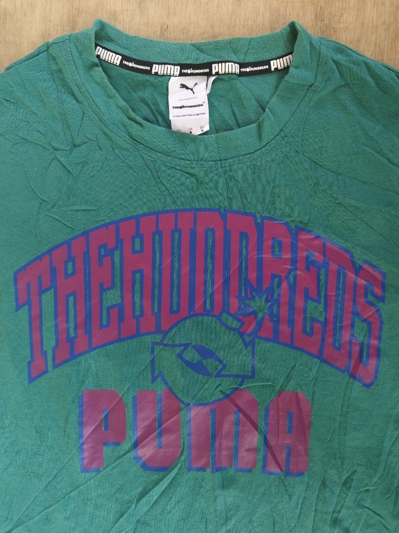 Puma x The Hundreds T-shirt (Category: Tshirts & Polo Shirts ) located in Butuan. Submitted by zhakmarcus (Listing ID 1434235120, Image 2). Description: - Puma x The Hundreds collaboration t-shirt - Color: Green - Size: M - Features: - Front: "THE HUNDREDS" and "PUMA" print - Back: "FOR THE WORLD" print - Style: Crew neck, short sleeves.