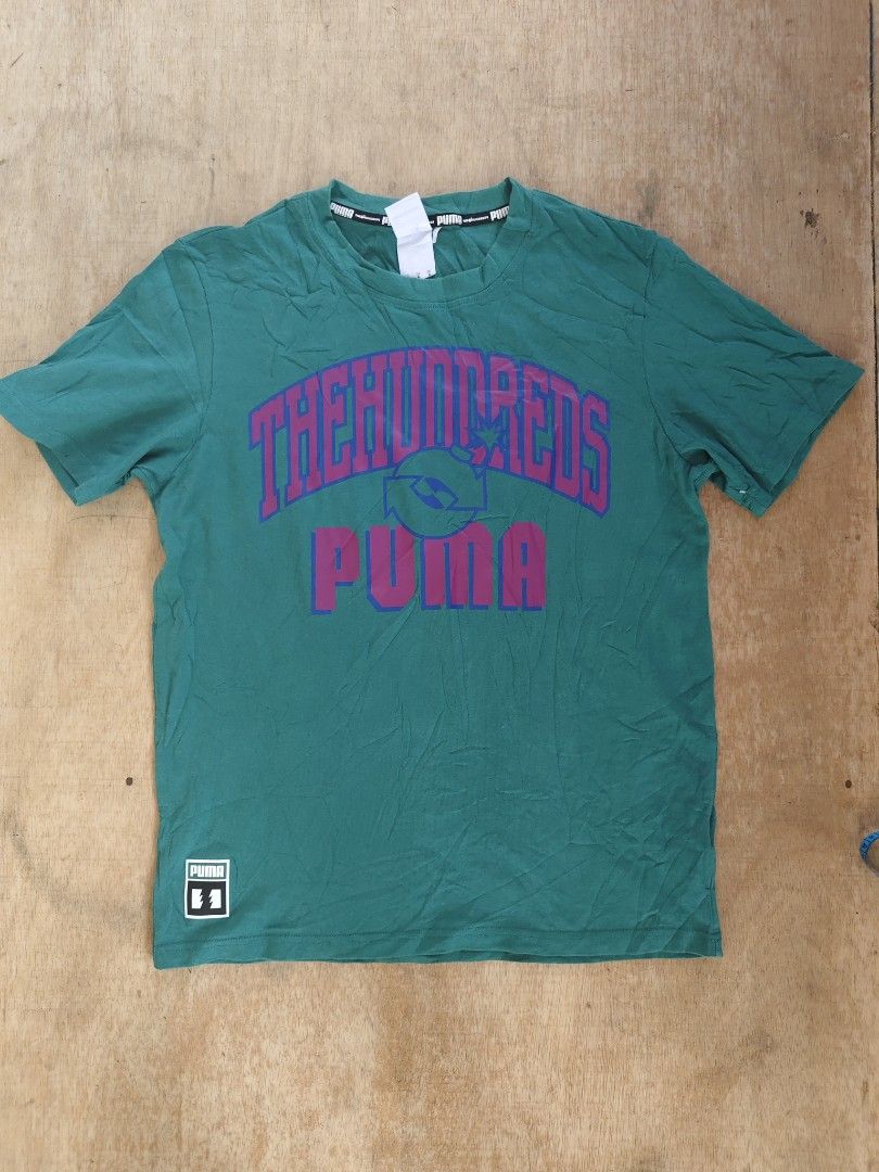 Puma x The Hundreds T-shirt (Category: Tshirts & Polo Shirts ) located in Butuan. Submitted by zhakmarcus (Listing ID 1434235120, Image 1). Description: - Puma x The Hundreds collaboration t-shirt - Color: Green - Size: M - Features: - Front: "THE HUNDREDS" and "PUMA" print - Back: "FOR THE WORLD" print - Style: Crew neck, short sleeves.