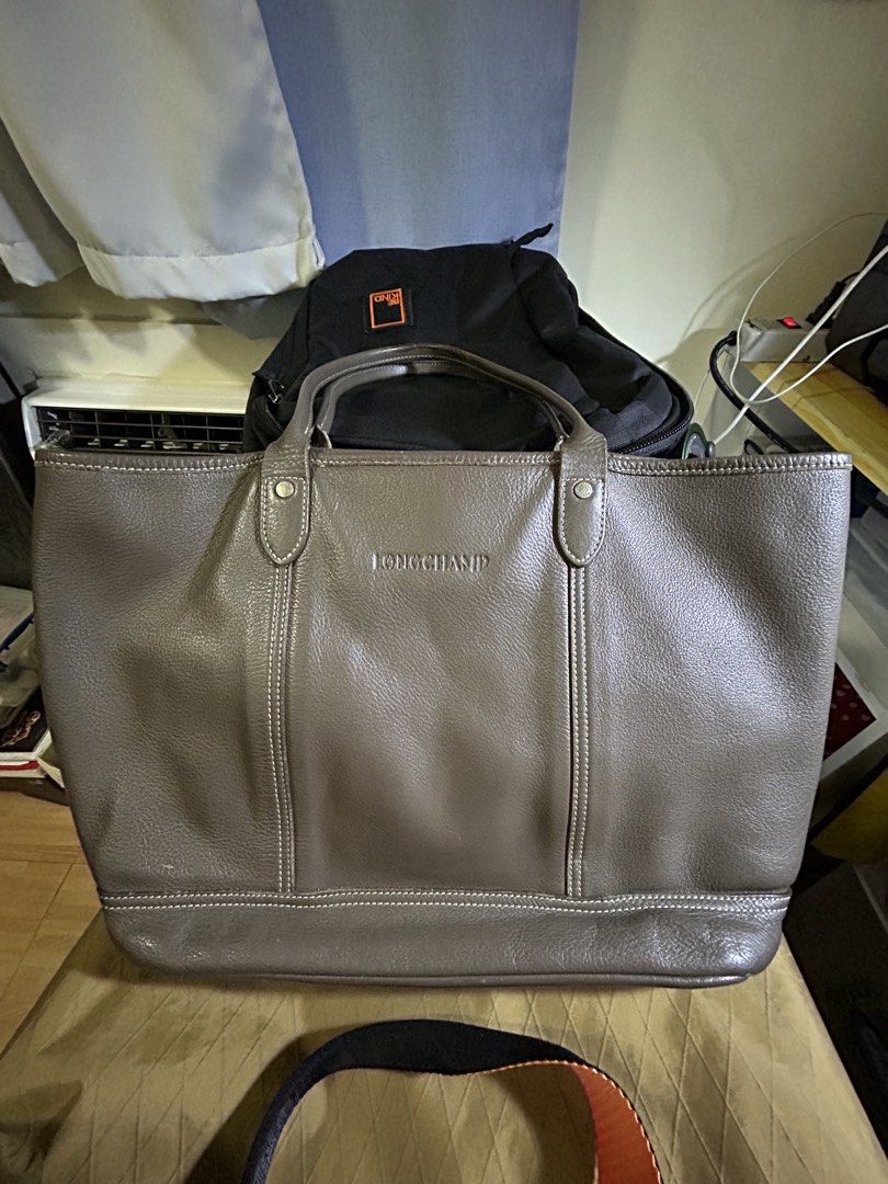 RARE Longchamp Leather Tote Bag (Category: Luxury Bags & Wallets) located in Manila. Submitted by victoria_victorino (Listing ID 1434339468, Image 1). Description: Longchamp leather tote bag. Features a spacious main compartment and two top handles. The bag has a neutral color with visible stitching details. Pink interior lining. 33 x 26 cm The Longchamp logo is embossed and displayed on the front. Bought in Poland, well loved..