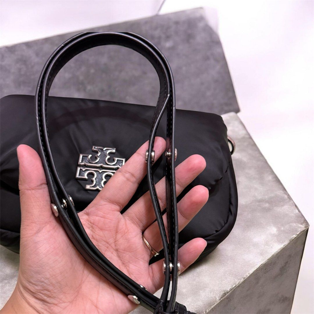 Tory Burch Puffer Nylon Crossbody (Category: Luxury Bags & Wallets) located in Caloocan City. Submitted by breelovedbags (Listing ID 1434303191, Image 3). Description: - Tory Burch Puffer Nylon Crossbody Bag - Britten Nylon Puffy Convertible model - Black color - Features the iconic Tory Burch logo - Stylish and versatile design - Perfect for everyday use Used twice or thrice only. Minor flaw (Small stain barely noticeable) Super nice in actual a