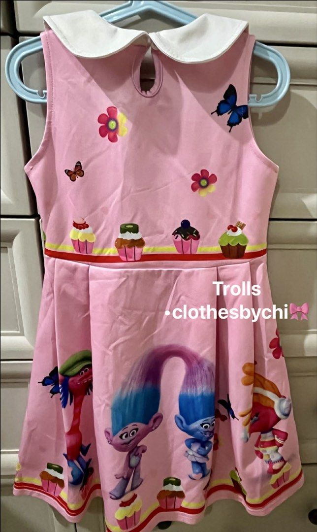 Trolls Dress Size 110 (6yo) (Category: Babies & Kids Fashion) located in Mandaluyong City. Submitted by acdp11 (Listing ID 1434277803, Image 2). Description: - Trolls-themed dress - Size fits approximately 6 years old - Features Trolls characters and cupcake print - White collar, sleeveless design - Worn once for a birthday - No tears or stains.