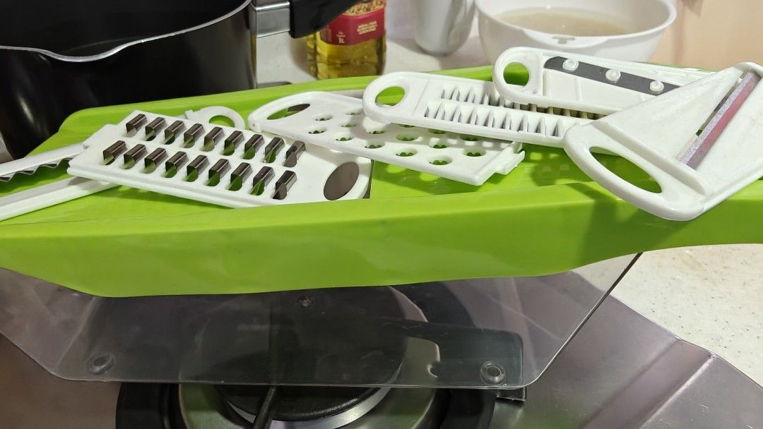 Vegetable Slicer with Multiple Blades (Category: Knives & Chopping Boards) located in Singapore. Submitted by hellokiara (Listing ID 1434384272, Image 1). Description: - Vegetable slicer with interchangeable blades. - Includes a green base and white blade attachments. - Perfect for various slicing and grating tasks..
