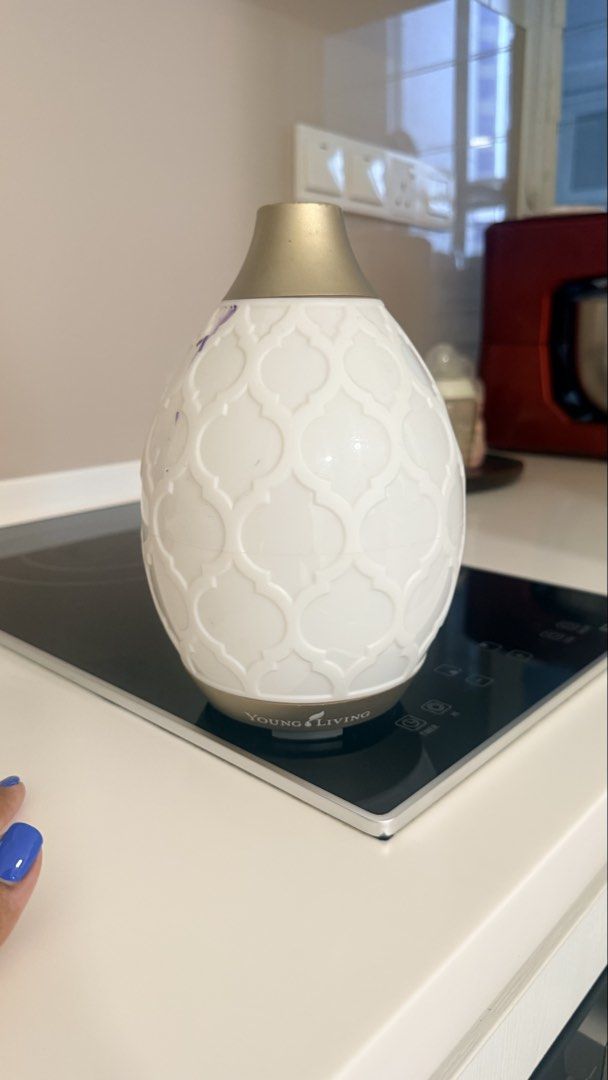 Young Living Diffuser (Category: Home Fragrance) located in Kuala Lumpur. Submitted by live.mimii (Listing ID 1434315513, Image 1). Description: - Young Living diffuser - White, patterned design with gold top - Young Living logo on base - Designed to disperse essential oils.
