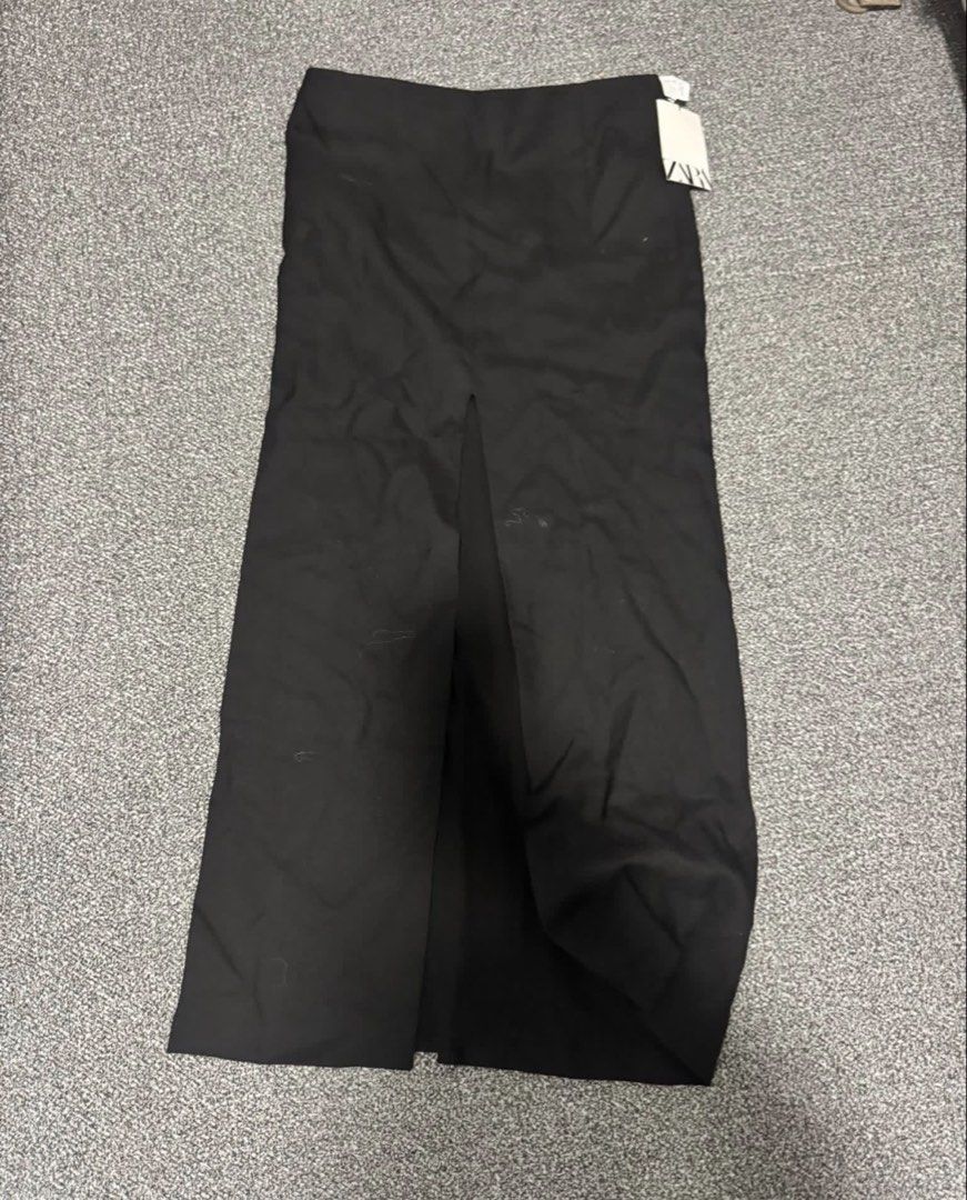 Zara Black Double Front Slit Midi Skirt (Category: Skirts) located in Muntinlupa City. Submitted by mishkarella (Listing ID 1434210449, Image 1). Description: Zara black midi skirt with a double front slit. It has a high waist design. The skirt has a tag attached..