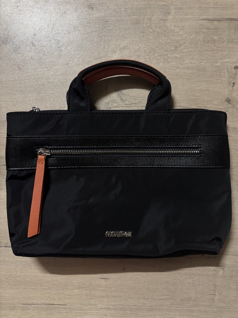 American Tourister Black Handbag (Category: Luxury Bags & Wallets) located in Taguig. Submitted by suzzsy (Listing ID 1434510096, Image 1). Description: - American Tourister black handbag - Top handle - Front zipper pocket with orange pull tab - Sleek design - Textured panel - Brand logo on front - Ideal for everyday use.