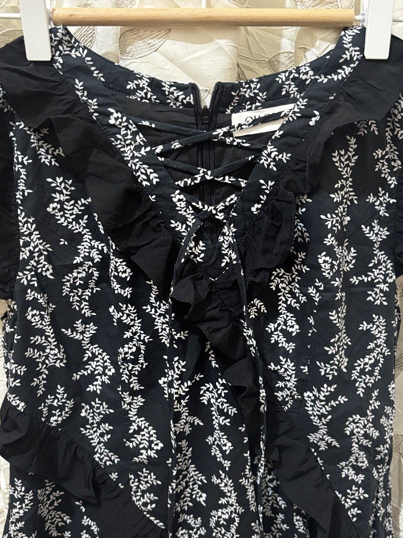 Black Floral Ruffle Dress (Category: Dresses) located in Baguio. Submitted by ravendoll.ph (Listing ID 1434475246, Image 3). Description: - Black dress with a delicate white floral pattern. - Ruffle detailing on the front and sleeves. - Tiered skirt. - Lace-up detail at the neckline. - Zipper closure at the back. - Sleeveless design. - Round neckline..
