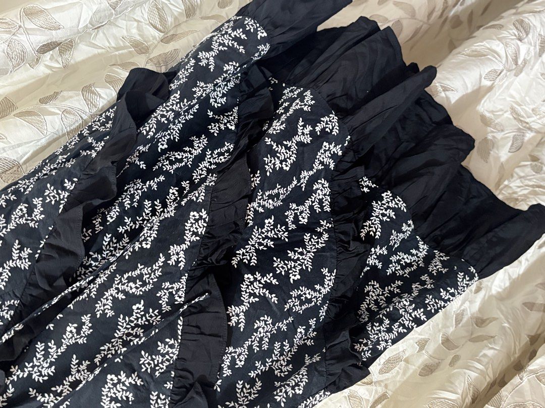 Black Floral Ruffle Dress (Category: Dresses) located in Baguio. Submitted by ravendoll.ph (Listing ID 1434475246, Image 2). Description: - Black dress with a delicate white floral pattern. - Ruffle detailing on the front and sleeves. - Tiered skirt. - Lace-up detail at the neckline. - Zipper closure at the back. - Sleeveless design. - Round neckline..
