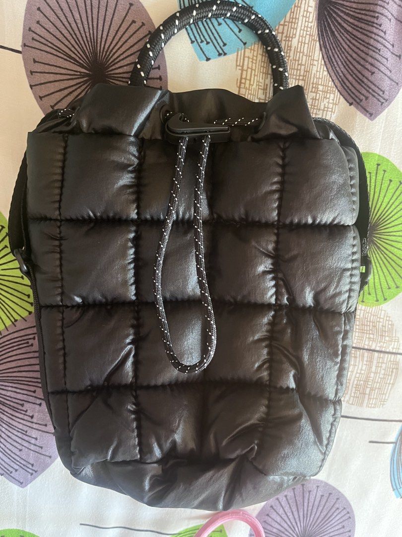 Black Padded Bucket Bag with Drawstring (Category: Shoulder Bags) located in Cainta. Submitted by llsamson2000 (Listing ID 1434390380, Image 1). Description: - Black quilted bucket bag - Drawstring closure - Top handle with rope-like texture - Detachable shoulder strap - Shiny, padded material - Nike logo detail.