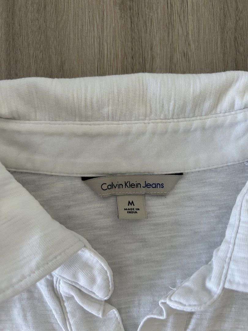 Calvin Klein White Polo Shirt (Category: Tshirts & Polo Shirts ) located in Taguig. Submitted by prelovedcloset2 (Listing ID 1434414658, Image 3). Description: - Calvin Klein Jeans polo shirt - Size: M - With some stains - see photos .