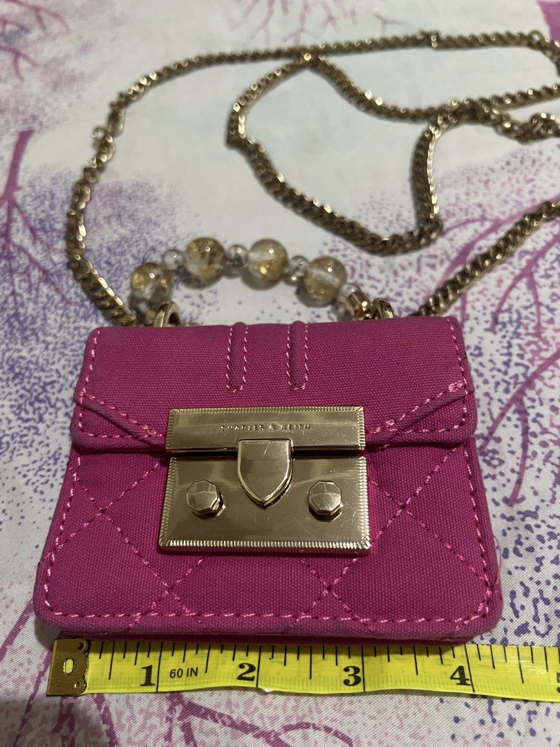 Charles & Keith Mini Bag with Chain (Category: Luxury Bags & Wallets) located in Dagupan City. Submitted by casadebayongph (Listing ID 1434544863, Image 2). Description: - Charles & Keith mini bag - Vibrant pink quilted design - Gold-tone chain strap with decorative beads - Rectangular shape with flap closure - Lined interior - Compact size for small essentials.