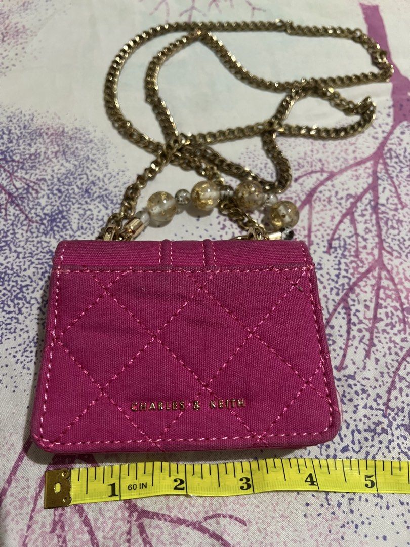 Charles & Keith Mini Bag with Chain (Category: Luxury Bags & Wallets) located in Dagupan City. Submitted by casadebayongph (Listing ID 1434544863, Image 3). Description: - Charles & Keith mini bag - Vibrant pink quilted design - Gold-tone chain strap with decorative beads - Rectangular shape with flap closure - Lined interior - Compact size for small essentials.
