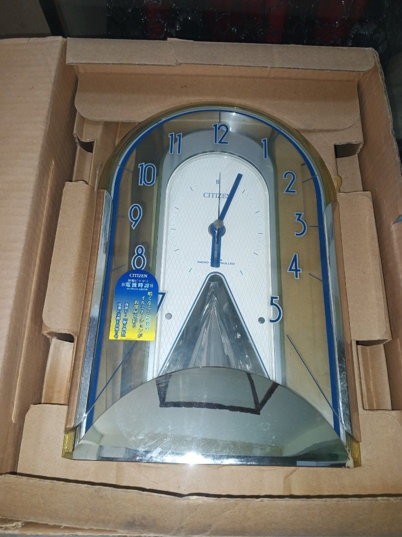 Citizen 4RY657-019 Silver Metallic Clock (Category: Clocks) located in Caloocan City. Submitted by surplusandbnewshop (Listing ID 1434425063, Image 1). Description: - Citizen clock with silver metallic finish - White clock face with blue accents and hands - Features a pendulum-like design - Includes original box and instruction manual - Unique arched design with clear plastic cover - Battery-operated.