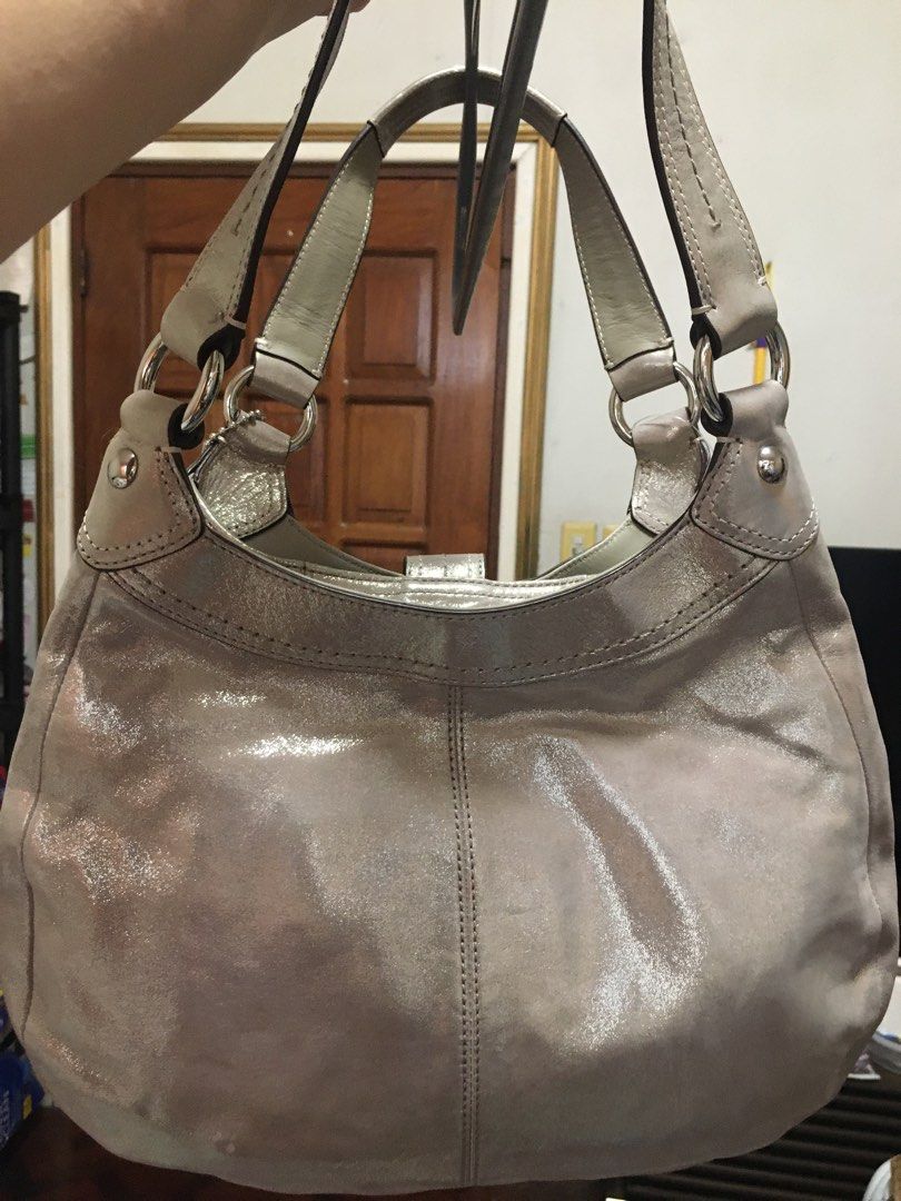 Coach Metallic Hobo Bag (Category: Luxury Bags & Wallets) located in Cebu City. Submitted by raidmycloset888 (Listing ID 1434391161, Image 3). Description: *Selling for a friend - purchased at a coach outlet in california -never been used. just stored in storage. -color : pewter - Coach metallic hobo bag - Silver hardware - Buckle closure - Coach hangtag - Purple lining - Multiple pockets - Shoulder straps #coach #bag.