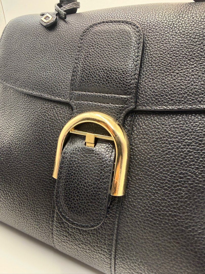 Delvaux Black Leather Handbag (Category: Luxury Bags & Wallets) located in Caloocan City. Submitted by rossvault2 (Listing ID 1434546797, Image 2). Description: - Delvaux black leather handbag - Top handle and detachable shoulder strap - Gold-tone buckle closure - Protective feet on the bottom - Interior zippered pocket - Textured leather finish - Includes 'D' charm -coded -ukay source, pls manage ur expectations -normal signs of use.