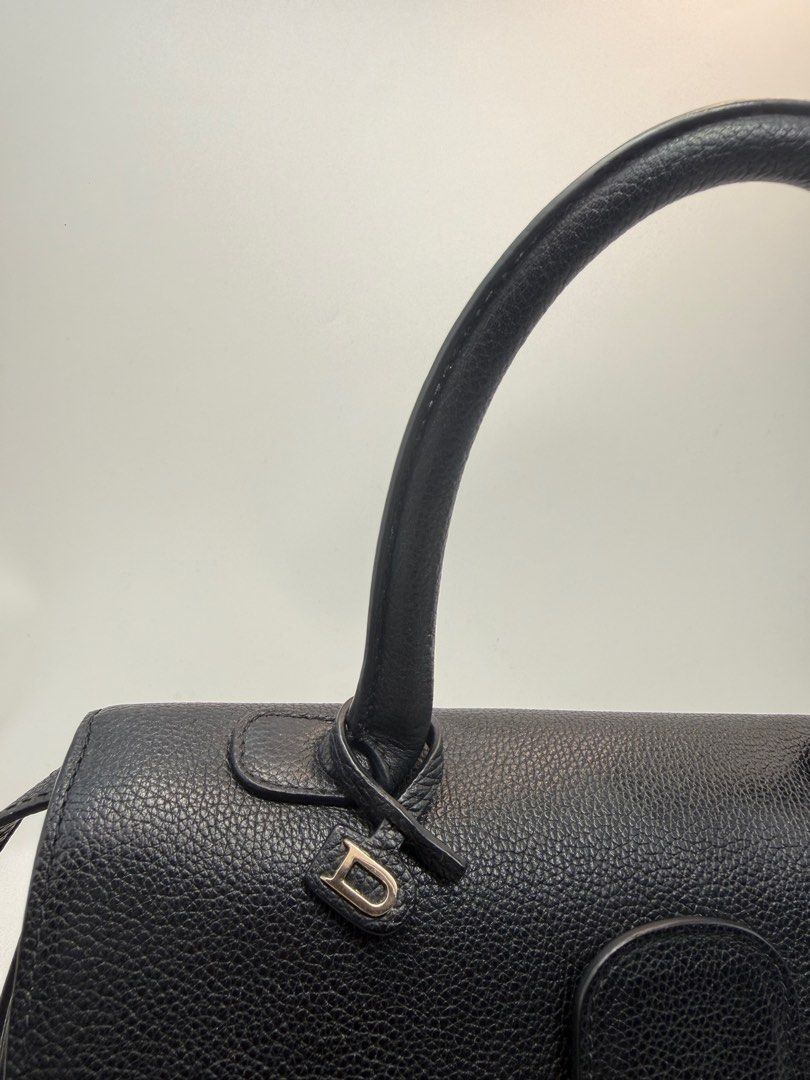 Delvaux Black Leather Handbag (Category: Luxury Bags & Wallets) located in Caloocan City. Submitted by rossvault2 (Listing ID 1434546797, Image 3). Description: - Delvaux black leather handbag - Top handle and detachable shoulder strap - Gold-tone buckle closure - Protective feet on the bottom - Interior zippered pocket - Textured leather finish - Includes 'D' charm -coded -ukay source, pls manage ur expectations -normal signs of use.