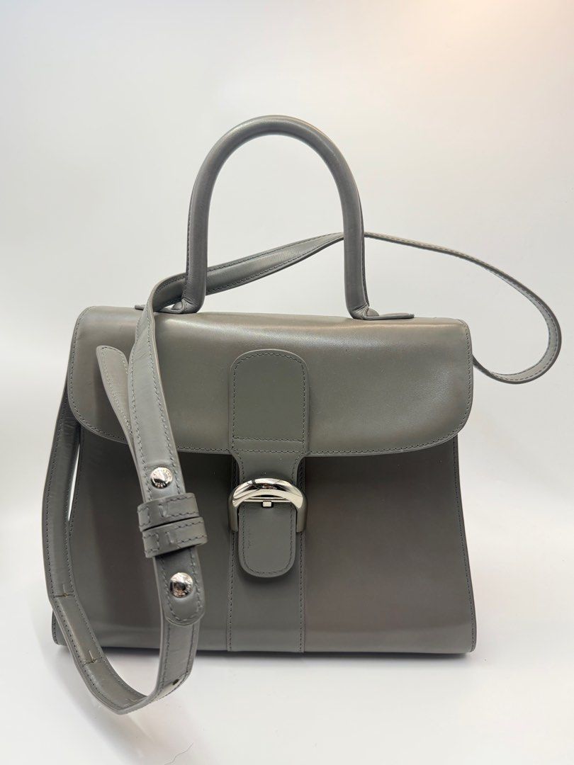 Delvaux Grey Leather bag (Category: Cross-body Bags) located in Caloocan City. Submitted by rossvault2 (Listing ID 1434533922, Image 1). Description: - Delvaux grey leather handbag - Top handle and detachable shoulder strap - Silver buckle closure - Interior with zippered pocket and compartments - Made in France - Minor wear on strap -coded/white tag -ukay source pls manage ur expectations -normal signs of use -sobrang kapal and structured .