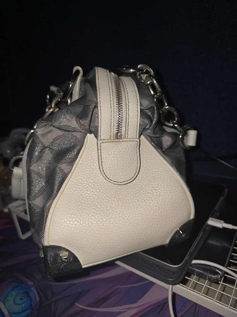MCM Silver Handbag with Chain Detail (Category: Luxury Bags & Wallets) located in Manila. Submitted by heartless724 (Listing ID 1434524050, Image 3). Description: - Stylish MCM handbag - Silver with white accents - Diamond pattern design - Chain details - White leather base - Zipper closure - Two yellow circular charms - Silver hardware - Structured shape.